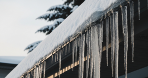 Gutter guards and icicles on snowy roof winter