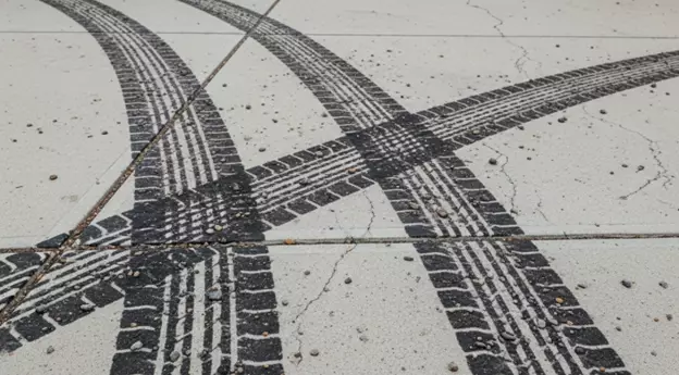 Tire marks on concrete driveway before cleaning