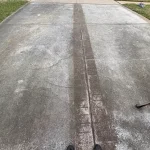 Concrete driveway with a clean pressure washed strip next to dirty concrete