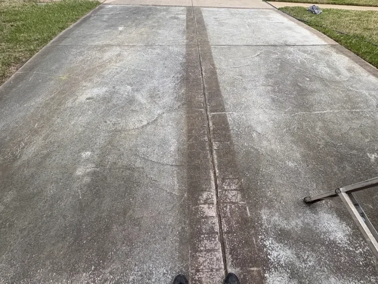 Concrete driveway with a clean pressure washed strip next to dirty concrete