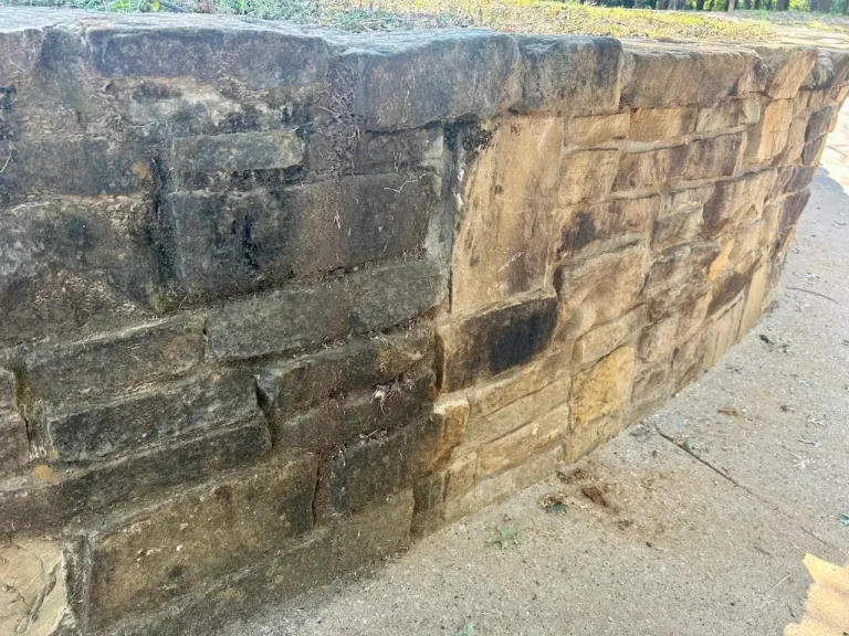 Stone retaining wall half cleaned showing before and after